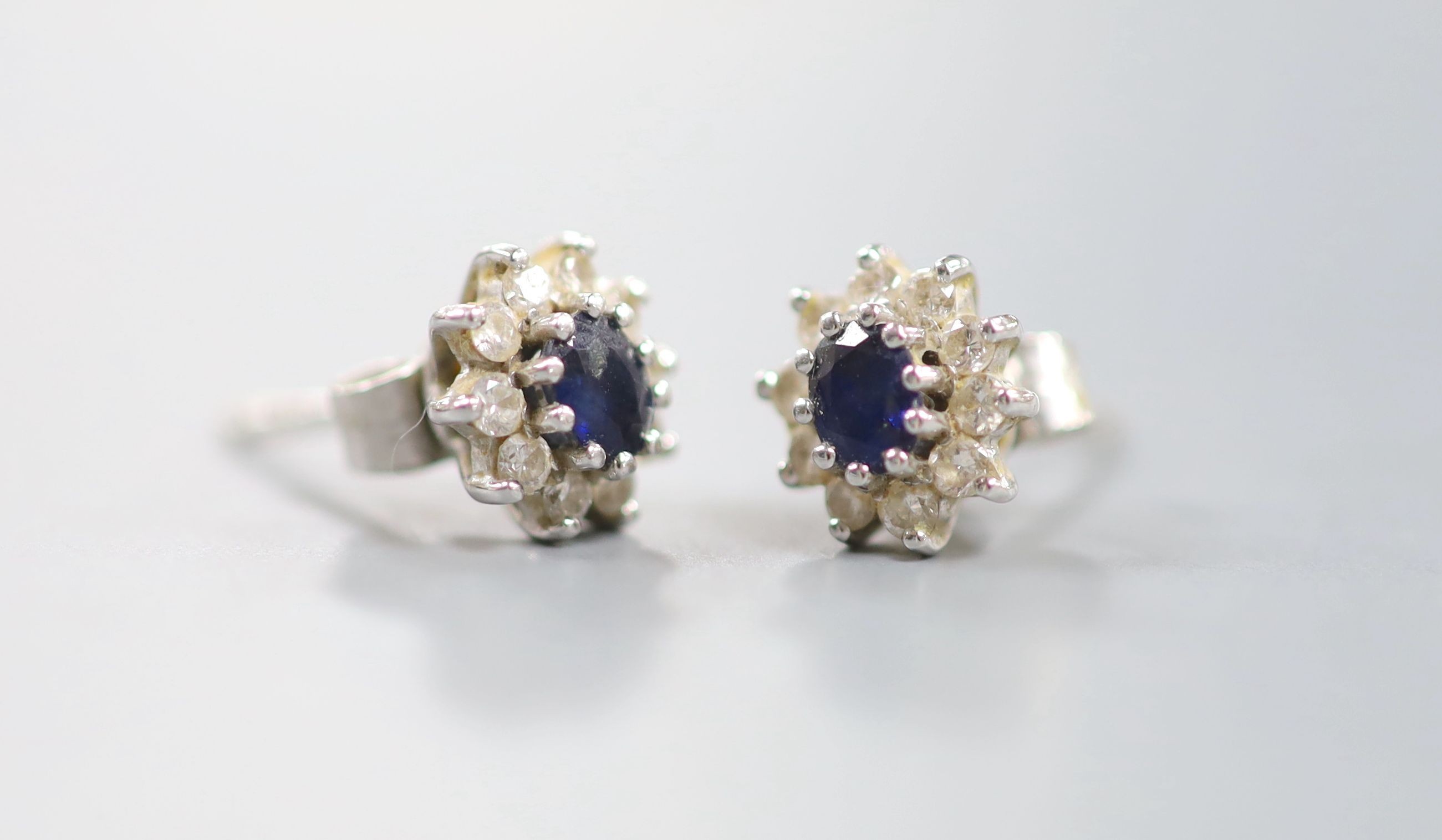 A small modern pair of 18ct white gold, sapphire and diamond cluster set ear studs, 7mm, gross weight 2.5 grams.